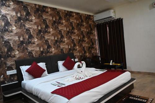 a bedroom with a large bed with red pillows at Kingfisher Resort in Dhanwār