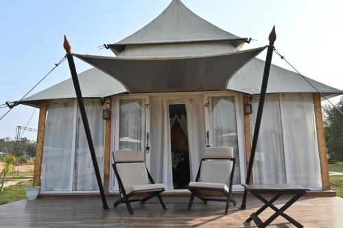 a gazebo with two chairs in front of it at Kingfisher Resort in Dhanwār
