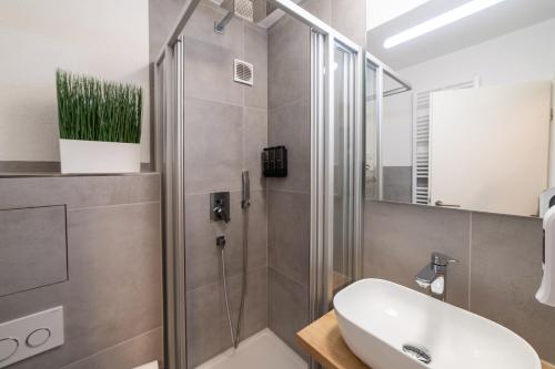 a bathroom with a shower and a white sink at Lovely Nest - Goeppingen City, Kitchen, Parking, Up to 4 People in Göppingen