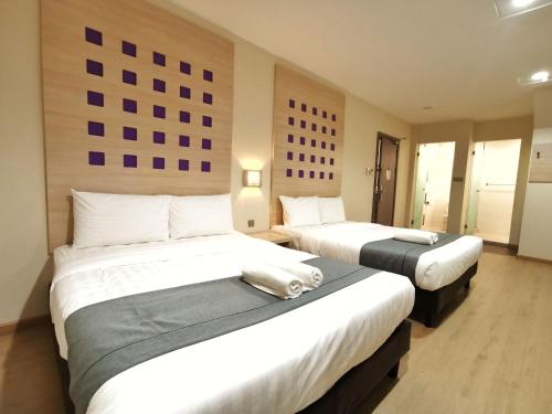 a hotel room with two beds in a room at Hotel 98 in Kuching
