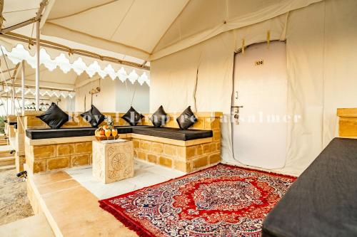 a room in a tent with a bench and a rug at Royal Empire Camp & Resort Jaisalmer in Sām