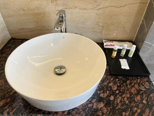 a white sink in a bathroom with a faucet at Landmark Bhairahawa in Bhairāhawā