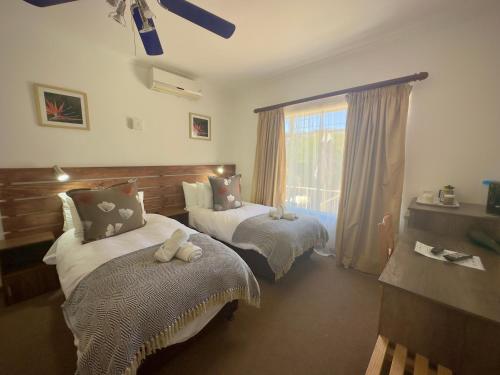 a bedroom with two beds and a window at Kliprand Guest House in Springbok