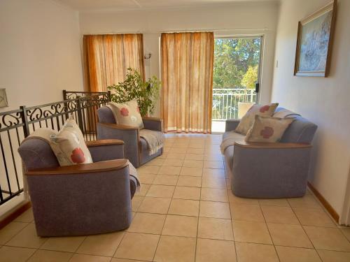 a living room with two chairs and a couch at Kliprand Guest House in Springbok