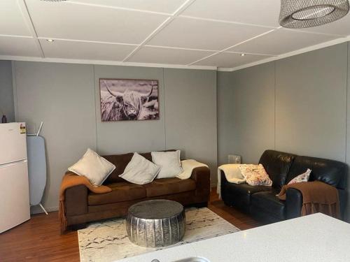 a living room with a couch and a table at Country Life in Tauranga