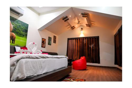 a bedroom with a bed with red pillows on it at Kingfisher Resort in Dhanwār