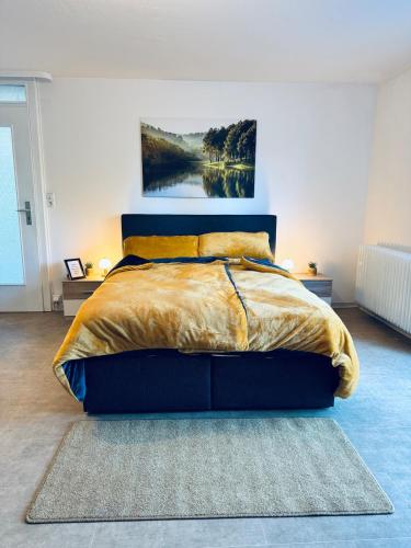 a bedroom with a bed with a painting on the wall at Apartment Schwarzwaldhöhen Pforzheim-Birkenfeld in Birkenfeld