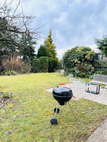 a bbq grill sitting in the grass in a yard at Apartment Schwarzwaldhöhen Pforzheim-Birkenfeld in Birkenfeld