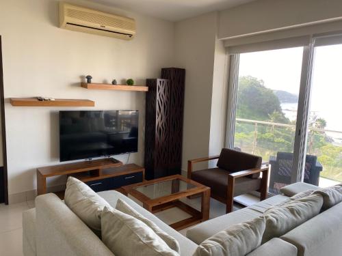 a living room with a couch and a television at Ponto Horizonte Manzanillo. Best place in Manzanillo!!! Luxury beach front condo, gorgeous views!! Best place you can stay!with up to 8 people. in Manzanillo