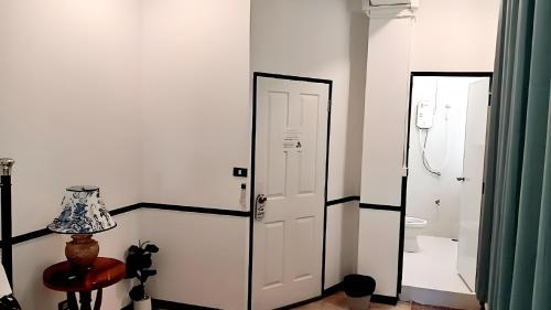a white room with a door and a mirror at The Character Yaowarat MRT วัดมังกร in Bangkok
