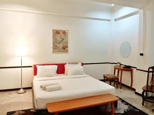 a bedroom with a white bed and a table at The Character Yaowarat MRT วัดมังกร in Bangkok