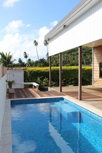a swimming pool in front of a house at Birdys Retreat in Rarotonga