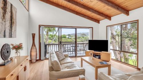 a living room with a couch and a tv at Coolabah Court in Merimbula