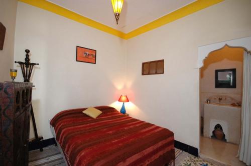 a bedroom with a bed in a room with a fireplace at Riad El Sagaya in Marrakech