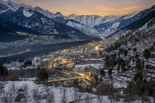 a view of a city in the snow with mountains at Echor Himalayan Heights Luxe Manali in Manāli