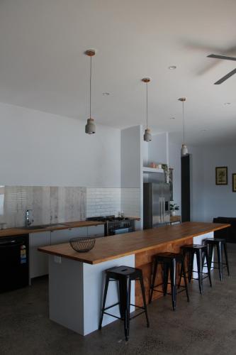 a kitchen with a wooden counter and some stools at Birdys Retreat in Rarotonga