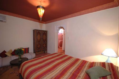 a bedroom with a bed and a table and a lamp at Riad El Sagaya in Marrakech
