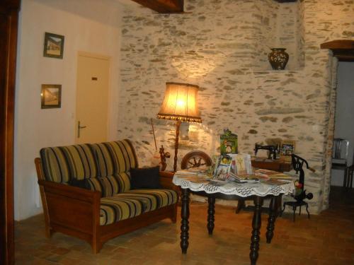a living room with a couch and a table with a lamp at Domaine de la Cour in Sainte-Gemme-dʼAndigné