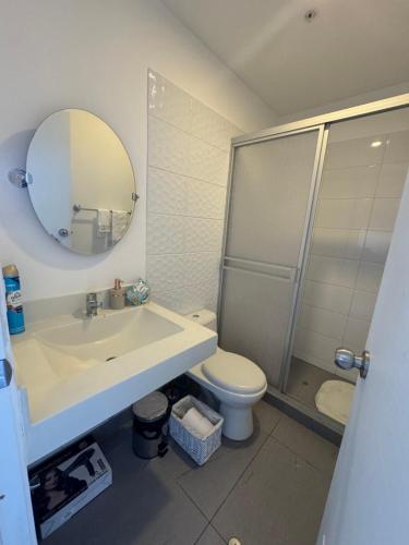 um banheiro com uma pia, um vaso sanitário e um espelho em Loft Ale Piso 22 em Lima