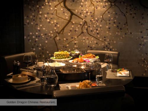 a table with dishes of food on it with lights at Grischa - Das Hotel Davos in Davos