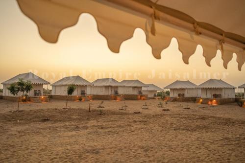 a group of huts on a beach with birds at Royal Empire Camp & Resort Jaisalmer in Sām