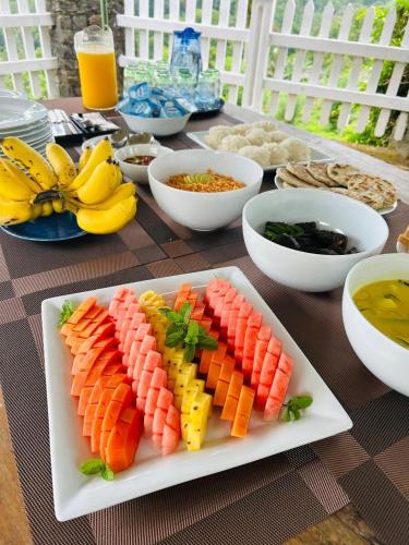a plate of fruits and vegetables on a table at Monticello Bungalow in Kotmale