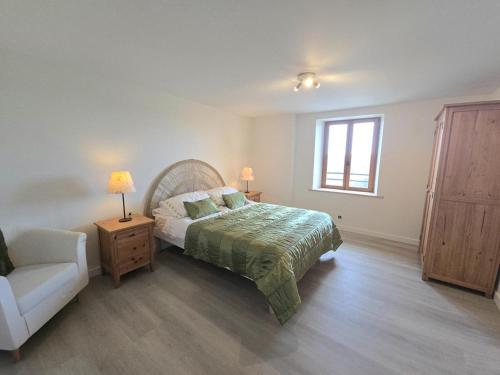 une chambre avec un lit, une chaise et une fenêtre dans l'établissement Gîte rénové avec piscine partagée à Saint-Méard-de-Drône - FR-1-616-468, à Villetoureix