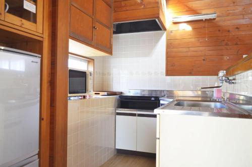 a small kitchen with a sink and a stove at Izumigo Yatsugatake Dog Paradise Cottage in Hokuto