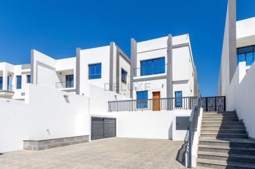 a white house with stairs in front of it at Sea-Facing 4BR Villa with Two Assistant Room, Heated Pool and Barbecue Space, Al Dana Island, Fujairah by Deluxe Holiday Homes in Fujairah