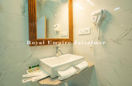 a bathroom with a sink and a phone and a mirror at Royal Empire Camp & Resort Jaisalmer in Sām