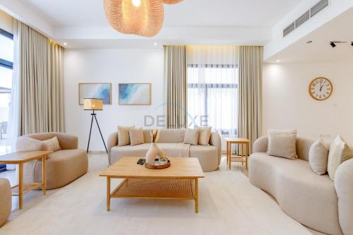 a living room with two couches and a table at Sea-Facing 4BR Villa with Two Assistant Room, Heated Pool and Barbecue Space, Al Dana Island, Fujairah by Deluxe Holiday Homes in Fujairah