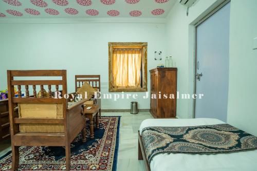 a bedroom with a bed and a dresser and a mirror at Royal Empire Camp & Resort Jaisalmer in Sām