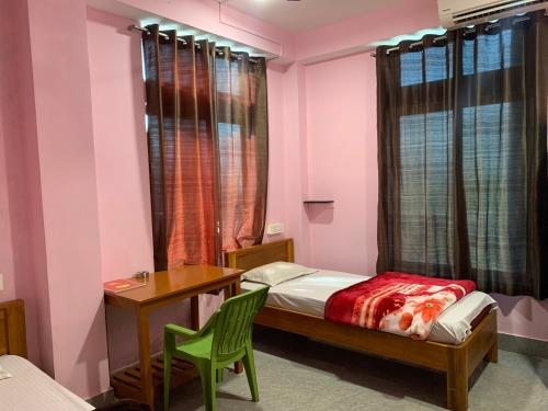 a bedroom with a bed and a desk and a table at Hotel City Centre -Fooding and Lodging, Best Hotel in Itānagar