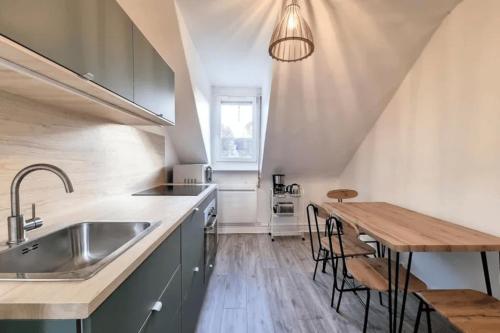 - une cuisine avec un évier et une table en bois dans l'établissement SOH Rent Strasbourg saint Florent proche Gare, à Strasbourg
