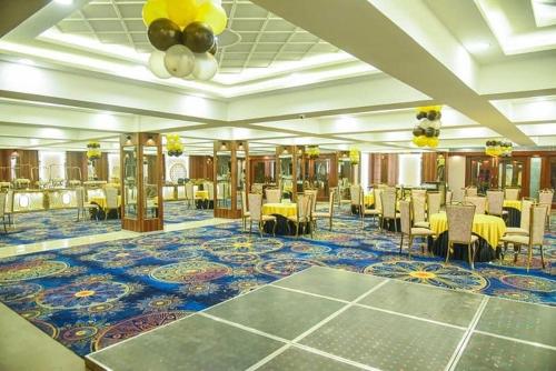 a banquet hall with yellow tables and chairs on a carpet at SK Premium Park GGN in Gurgaon