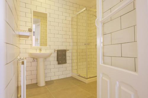 een witte badkamer met een wastafel en een spiegel bij Amar Hostel & Suites in Ericeira