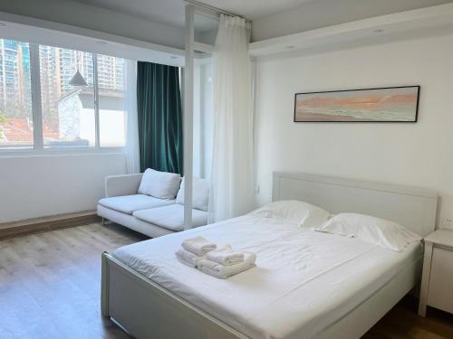 Un dormitorio con una cama con dos toallas encima. en flowerzhaohuaxishi, en Shanghái