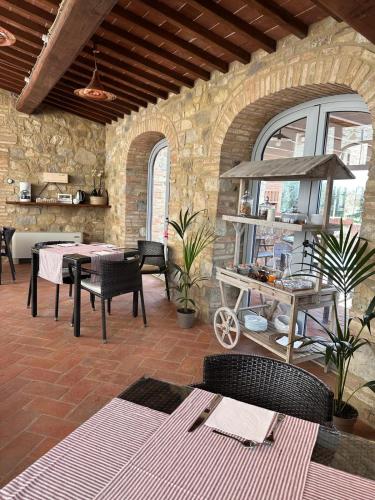 a patio with tables and chairs and a stone wall at Relais Casanova in San Gusmè