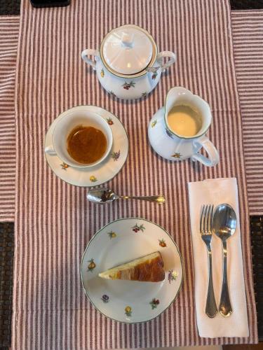 a table with two cups of coffee and a piece of cake at Relais Casanova in San Gusmè