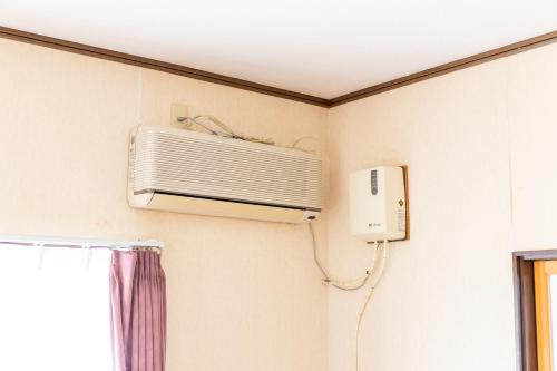 a air conditioner on a wall in a room at 民泊よこてこよ in Yokote