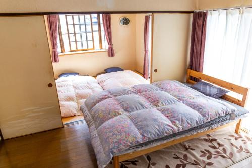 a bedroom with a bed and a window at 民泊よこてこよ in Yokote