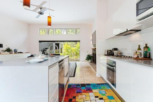 a kitchen with white counters and a colorful rug on the floor at Deja Vu Estate in Pokolbin