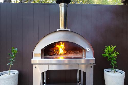 a fire oven with two potted plants next to it at Deja Vu Estate in Pokolbin