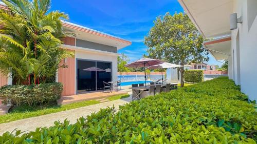 a villa with a swimming pool and a patio with umbrellas at The Memories Hill Phuket in Thalang
