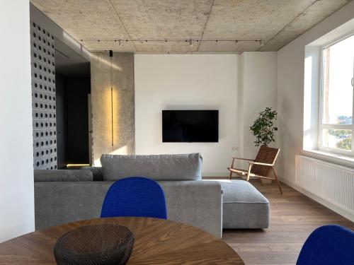 a living room with a couch and a tv at Двокімнатний люкс в ЖК над Бугом in Khmelʼnytsʼkyy