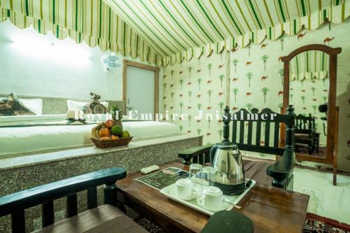 a room with a bed and a table with a coffee maker at Royal Empire Camp & Resort Jaisalmer in Sām