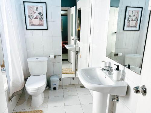 a white bathroom with a toilet and a sink at Apartment P - 3 Bedrooms in Belas