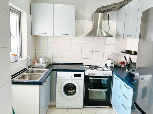 a kitchen with a washing machine and a sink at Apartment P - 3 Bedrooms in Belas