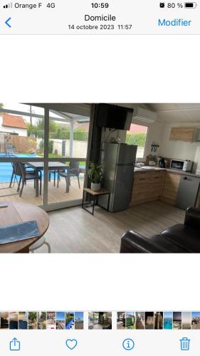 a view of a kitchen and a living room with a table at Tiny house in Hermanville-sur-Mer