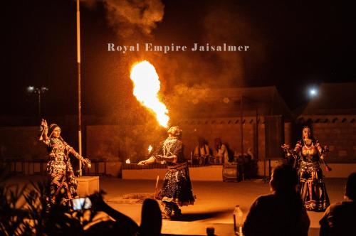 a group of women performing a fire show at night at Royal Empire Camp & Resort Jaisalmer in Sām